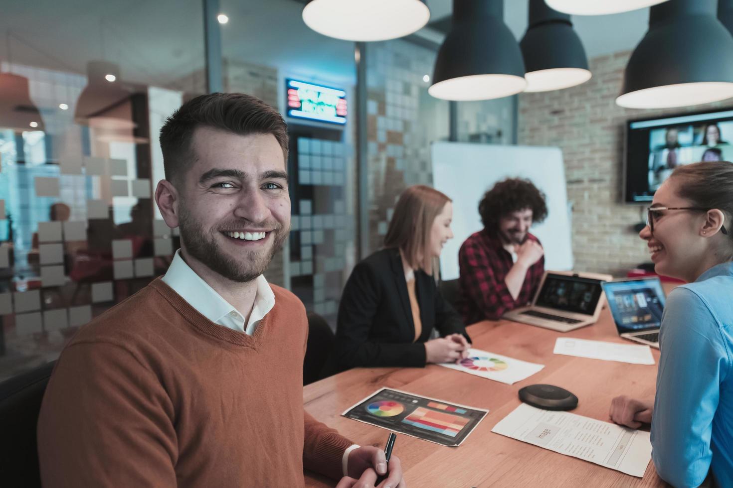 Successful team. Group of young multi-ethnic business people working and communicating together in creative office. Selective focus photo