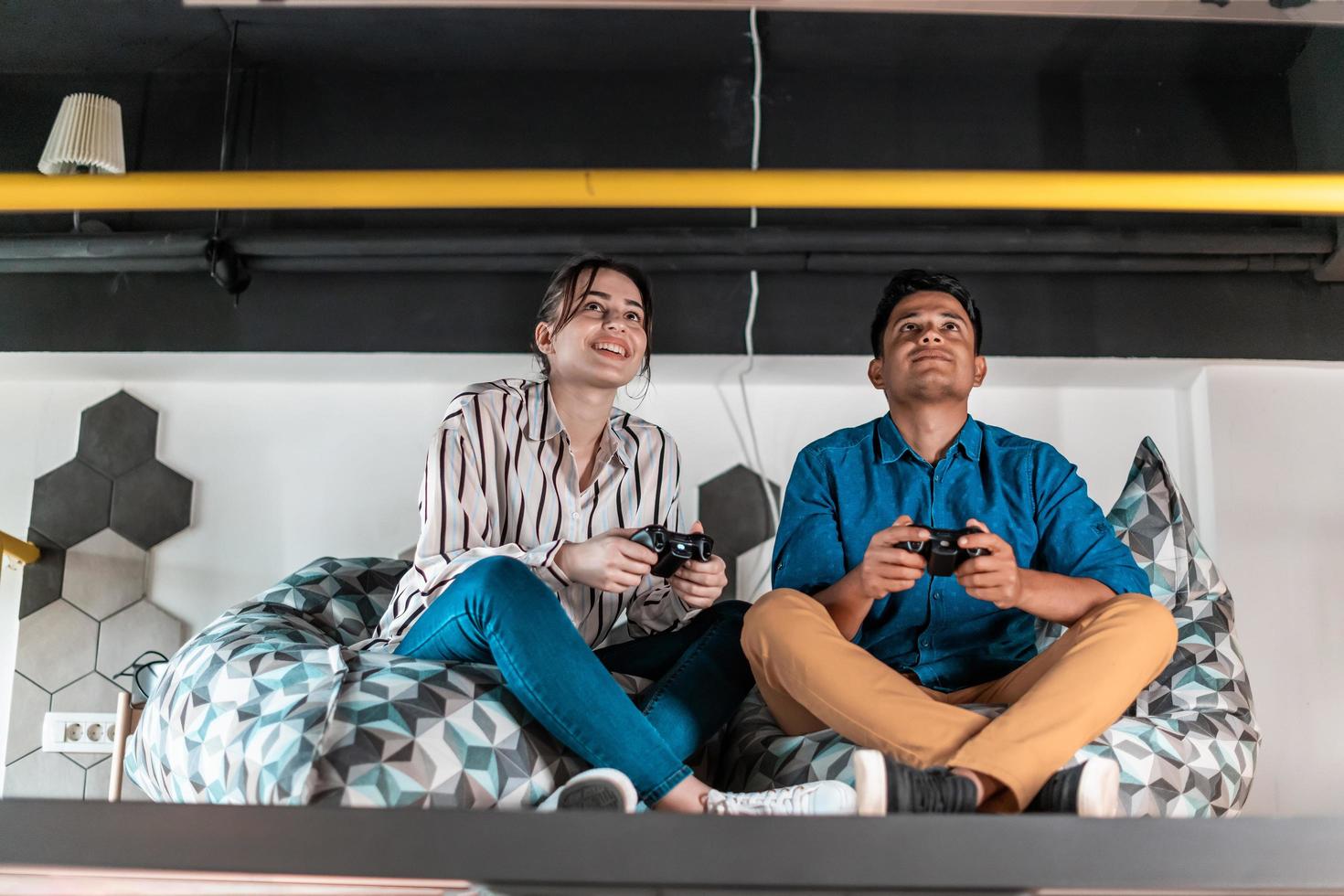 Work hard play hard. Workers Playing computer games man against woman during break in relaxation area at creative startup Office photo