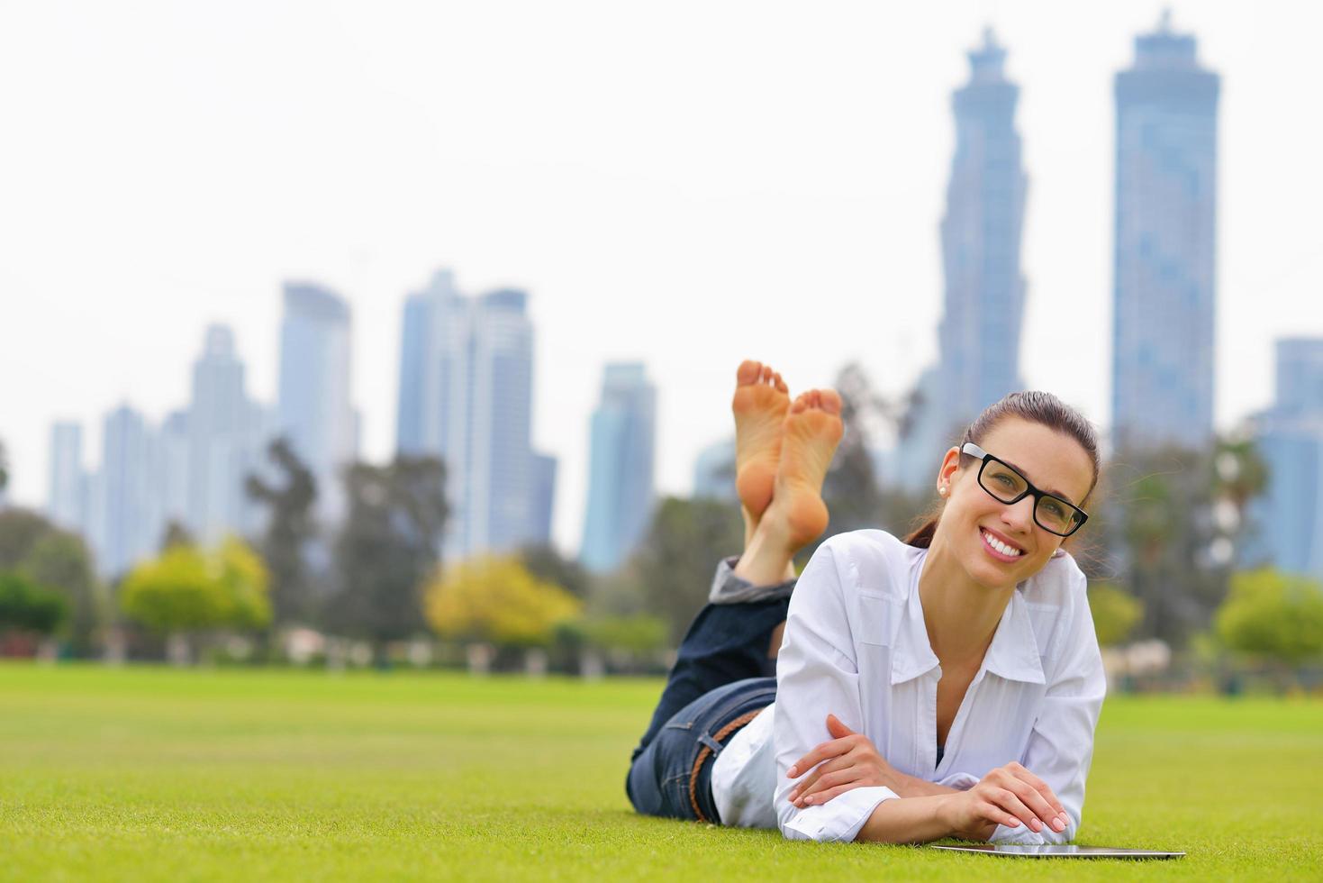 Beautiful young woman with  tablet in park photo