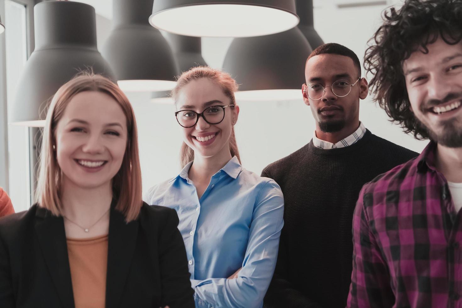 Portrait of successful creative business team looking at camera and smiling. Diverse business people standing together at startup. Selective focus photo