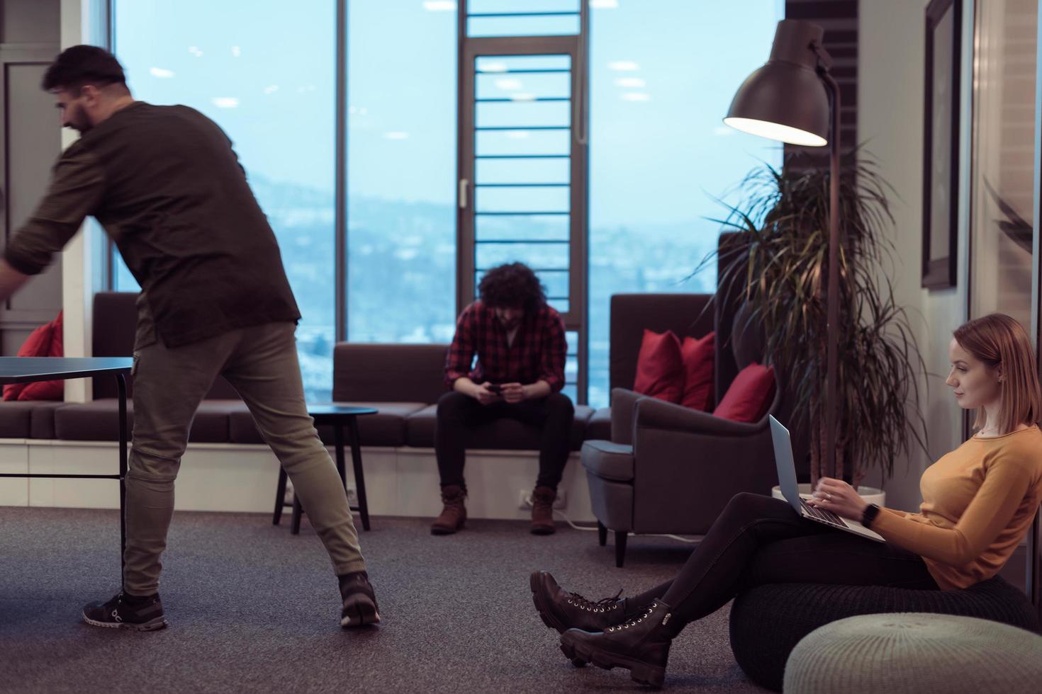 Two business women sitingt in a modern coworking space on a break from work and relax using a laptop. Selective focus photo