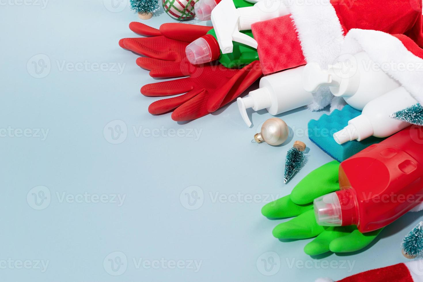 Christmas cleaning. Cleaning tools and Christmas decorations top view flat lay on blue background with copy space photo