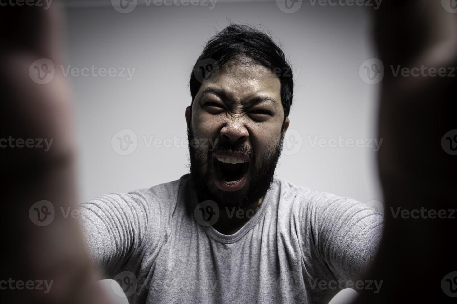 retrato de un joven asiático de fondo blanco, concepto de hombre enojado foto
