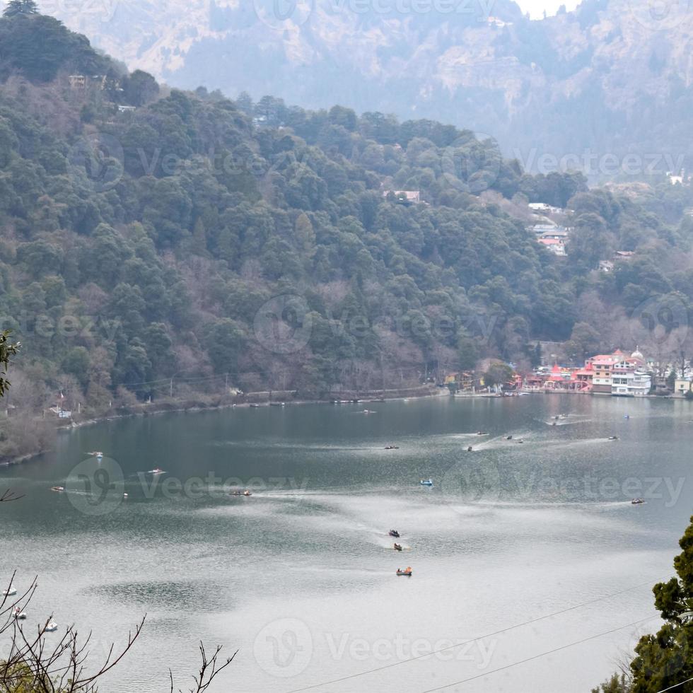 Full view of Naini Lake during evening time near Mall Road in Nainital, Uttarakhand, India, Beautiful view of Nainital Lake with mountains and blue sky photo