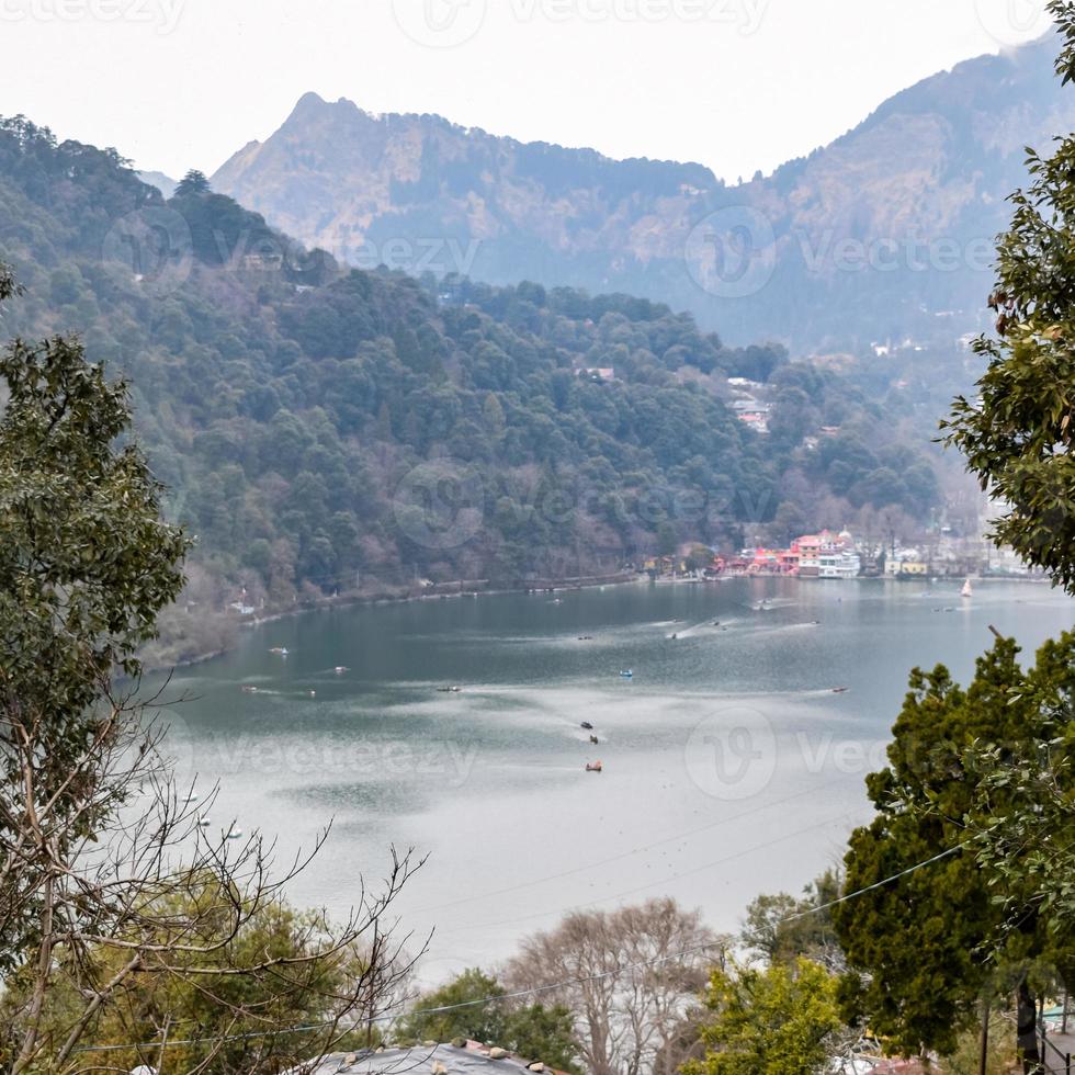 Full view of Naini Lake during evening time near Mall Road in Nainital, Uttarakhand, India, Beautiful view of Nainital Lake with mountains and blue sky photo