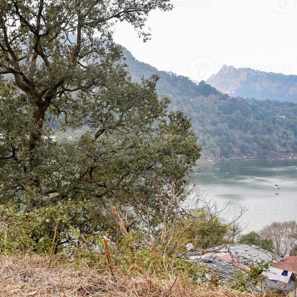 Full view of Naini Lake during evening time near Mall Road in Nainital, Uttarakhand, India, Beautiful view of Nainital Lake with mountains and blue sky photo