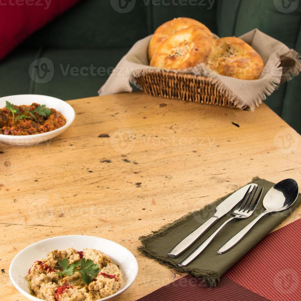 A close up shot of a appetizers near basket of breads on a wooden table photo
