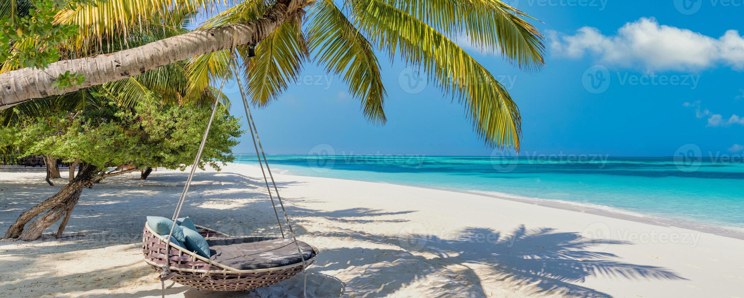 Beautiful Maldives. Tropical beach panorama as summer landscape, beach swing or hammock, sea sand sky for luxury beach banner. Perfect beach coast vacation and summer holiday. Tranquil paradise island photo