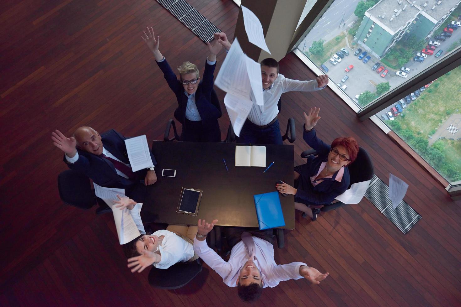 top view of business people group throwing dociments in air photo