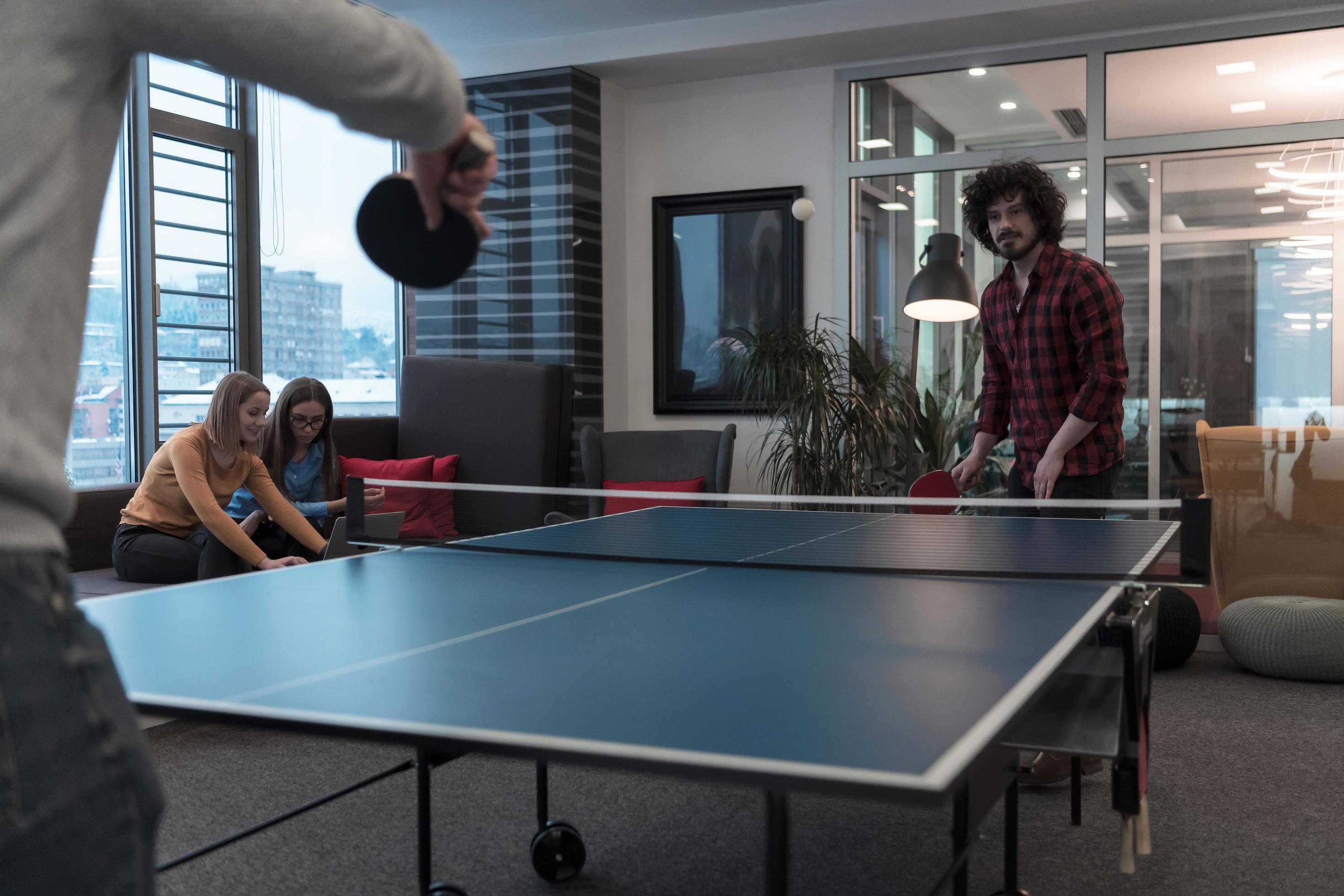 Two young start up business man playing ping pong tennis at modern creative  office space people group have meeting and brainstorming in background  12508352 Stock Photo at Vecteezy