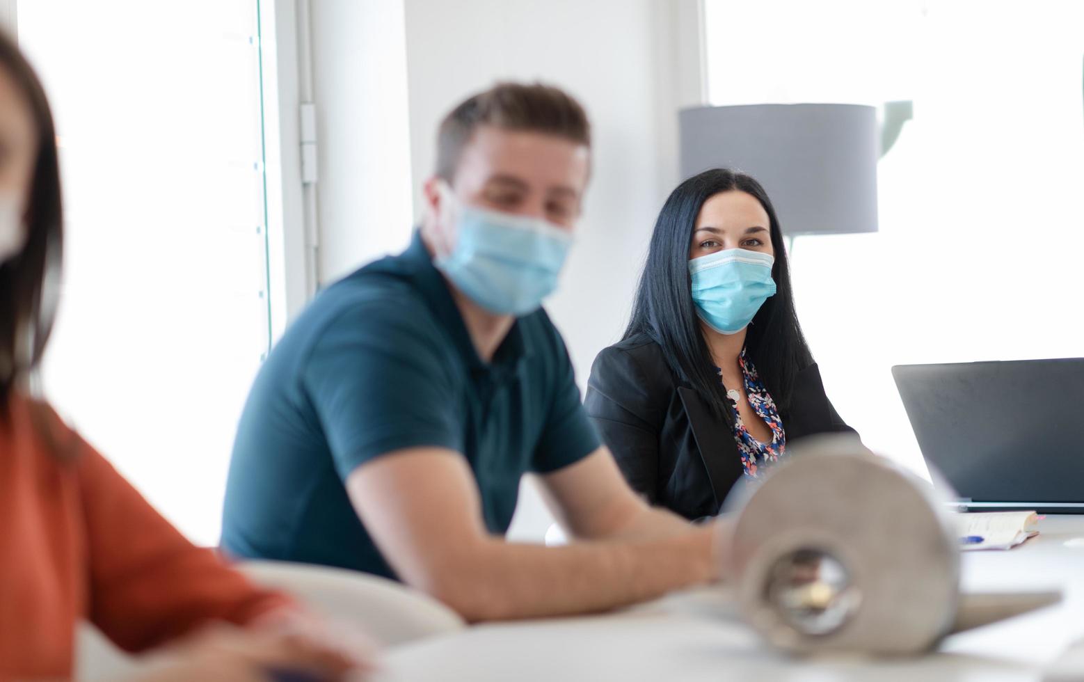 real business people on meeting wearing protective mask photo