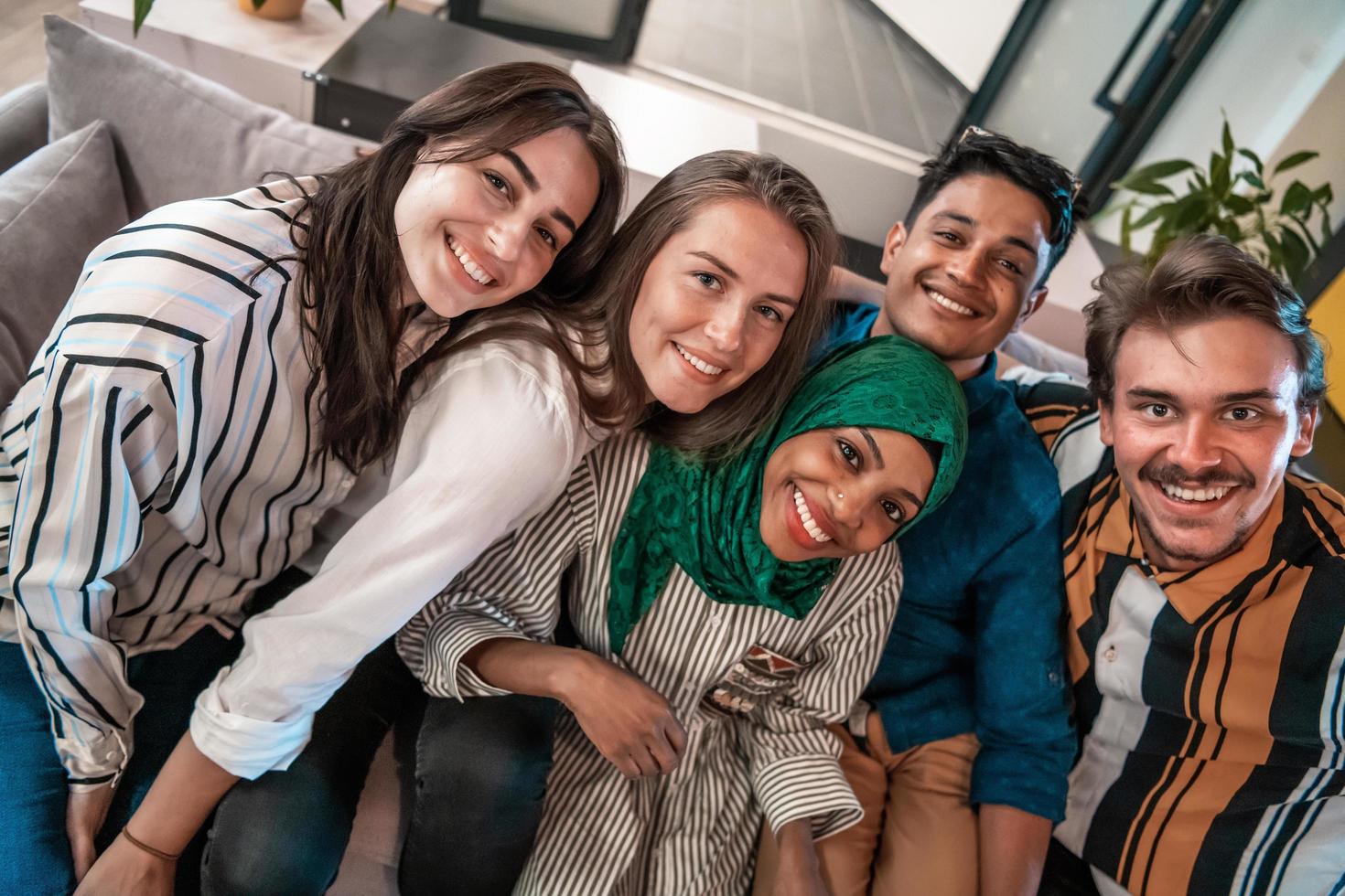 Group of business people during break from the work taking selfie picture while enjoying free time in relaxation area at modern open plan startup office. Selective focus photo