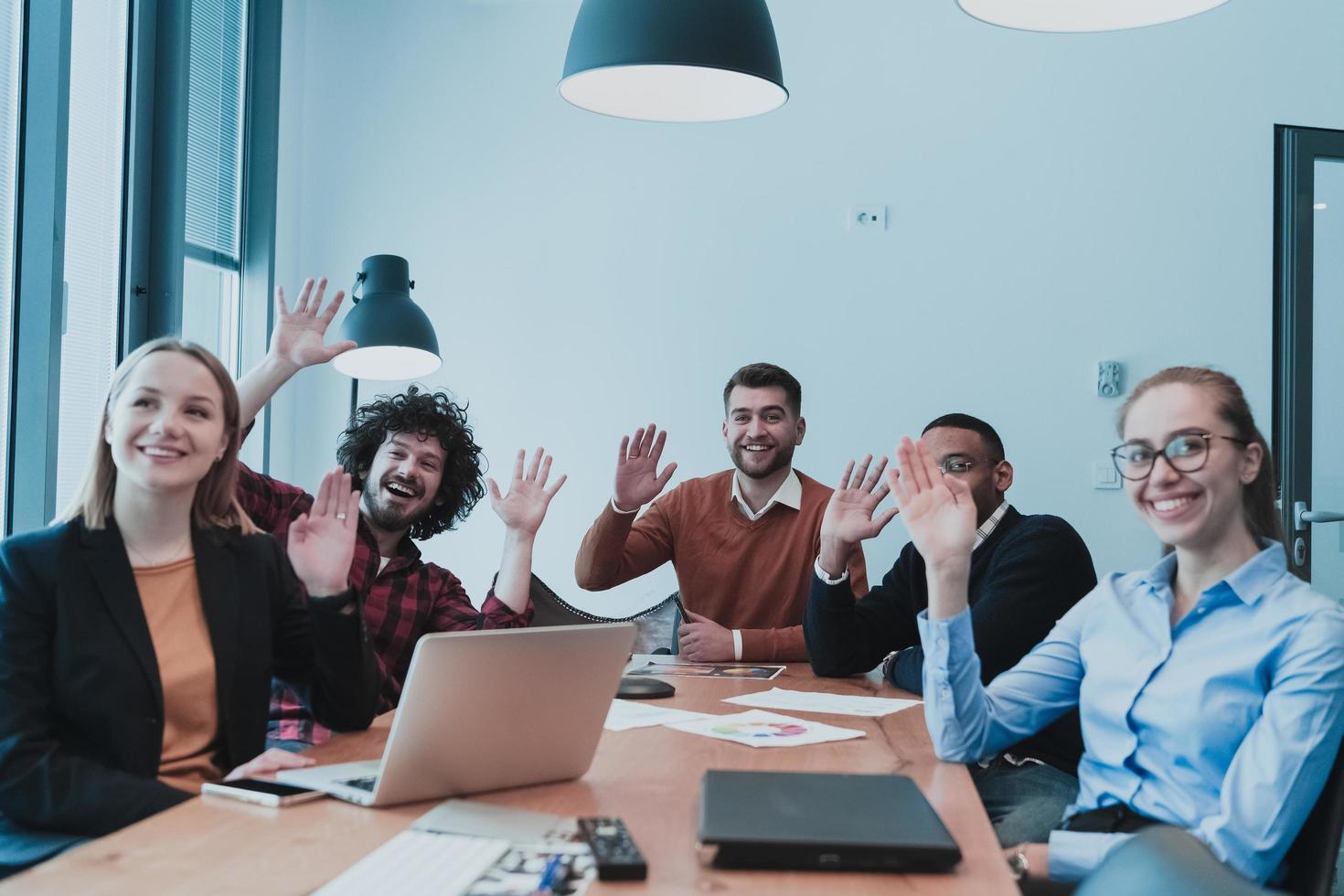 los jóvenes levantan la mano para hacer preguntas en el entrenamiento del equipo, el empleado negro curioso o el participante del seminario de la conferencia votan como voluntarios en la reunión de la oficina del grupo con empresarios multirraciales diversos foto