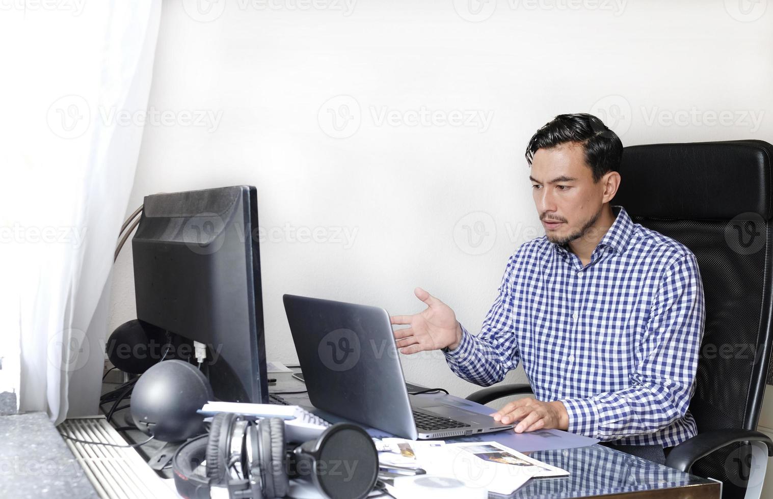 Man with worried and confused look holding hear while looking at the laptop photo