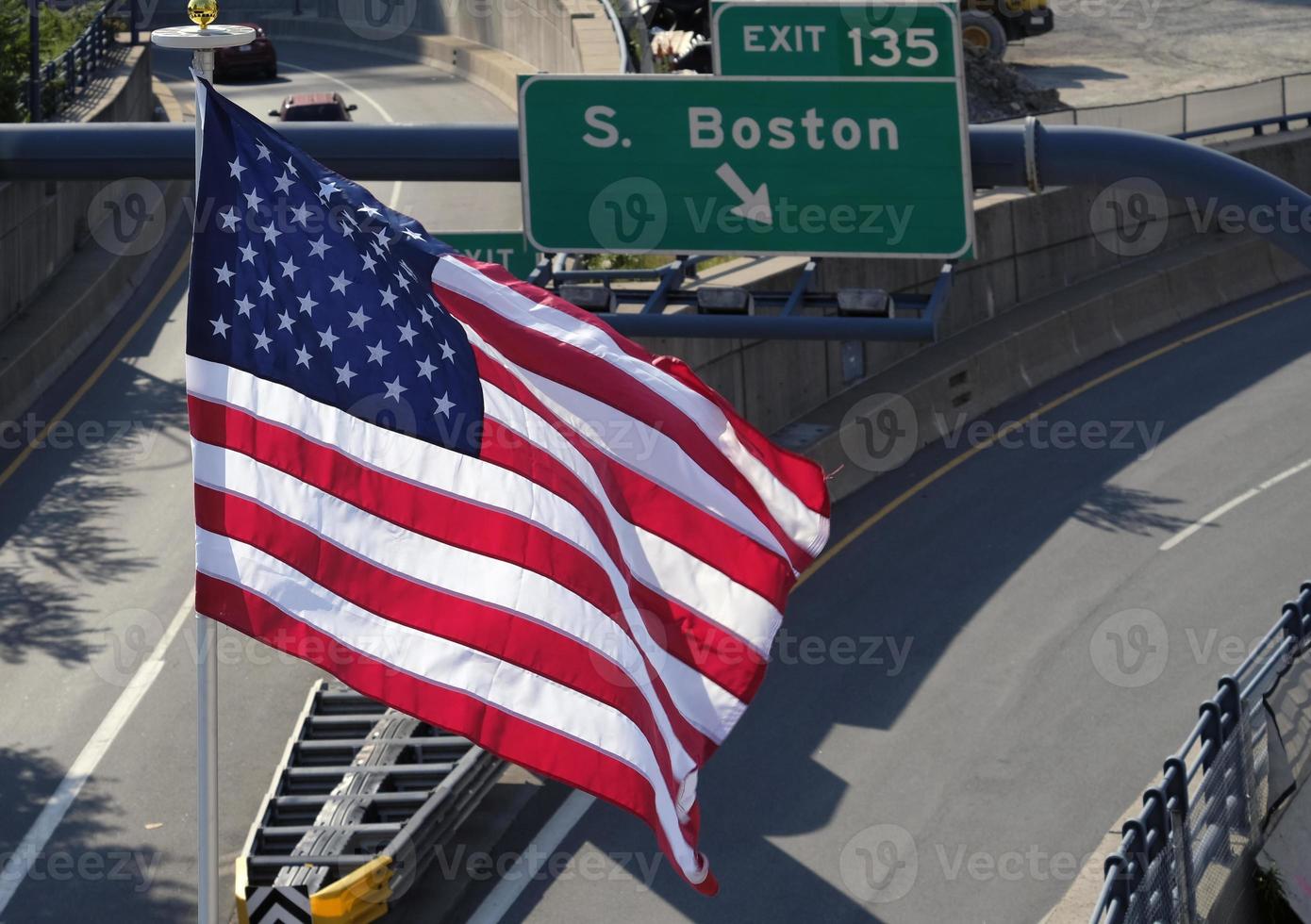 bandera estadounidense junto a la salida de una autopista a boston foto