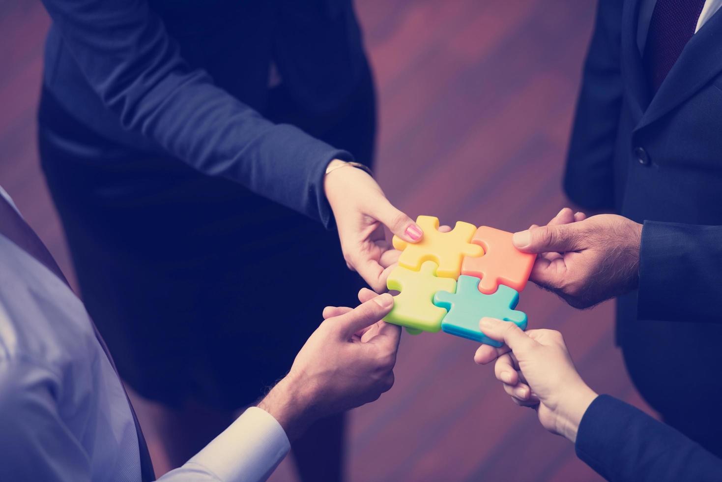 top view of business people group assembling jigsaw puzzle photo