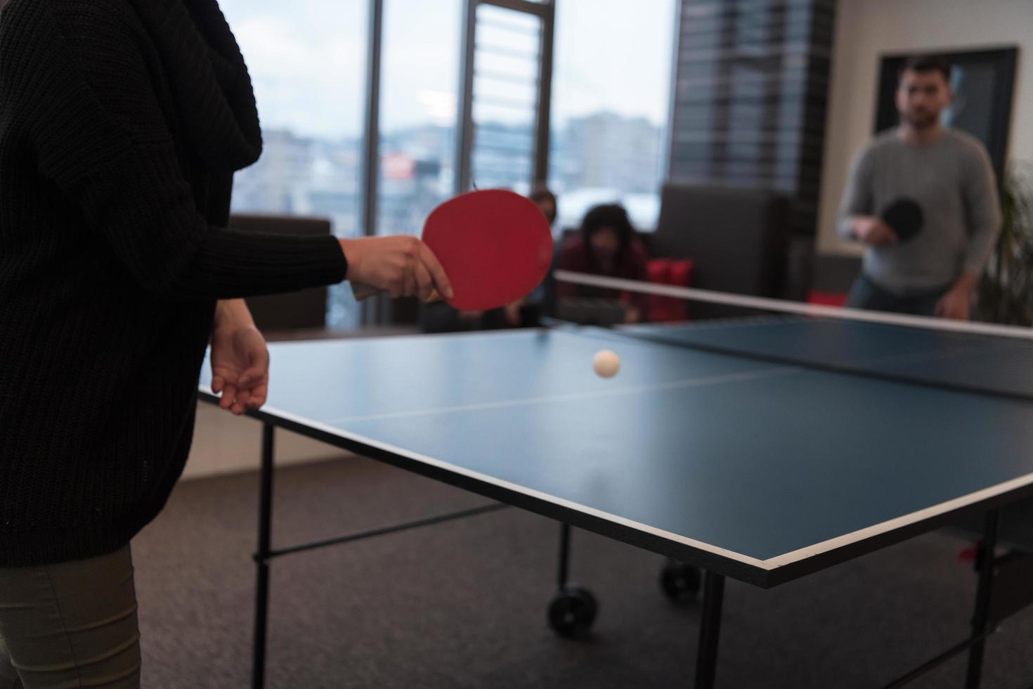 Two young start up business man playing table tennis at modern creative office space people group have meeting and brainstorming in background photo
