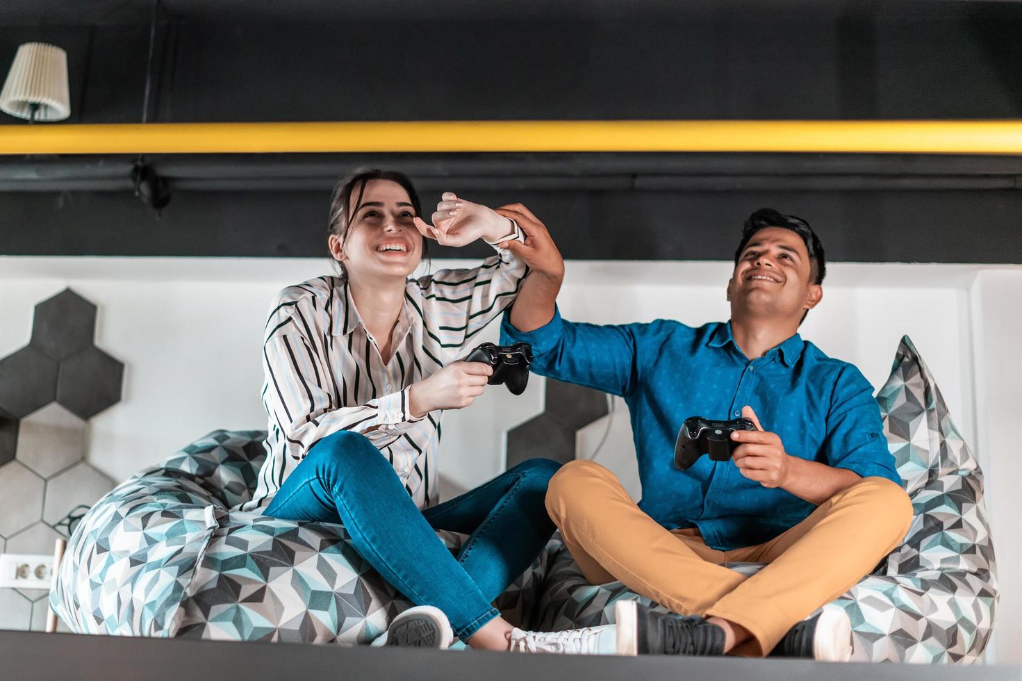 Work hard play hard. Workers Playing computer games man against woman during break in relaxation area at creative startup Office photo