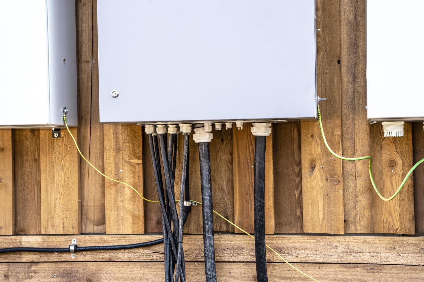 electrical panels and electrical cables connected to them on the wall photo