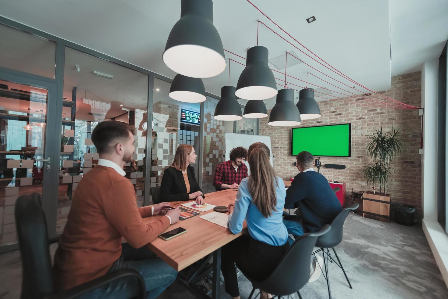 Successful team. Group of young multi-ethnic business people working and communicating together in creative office. Selective focus photo