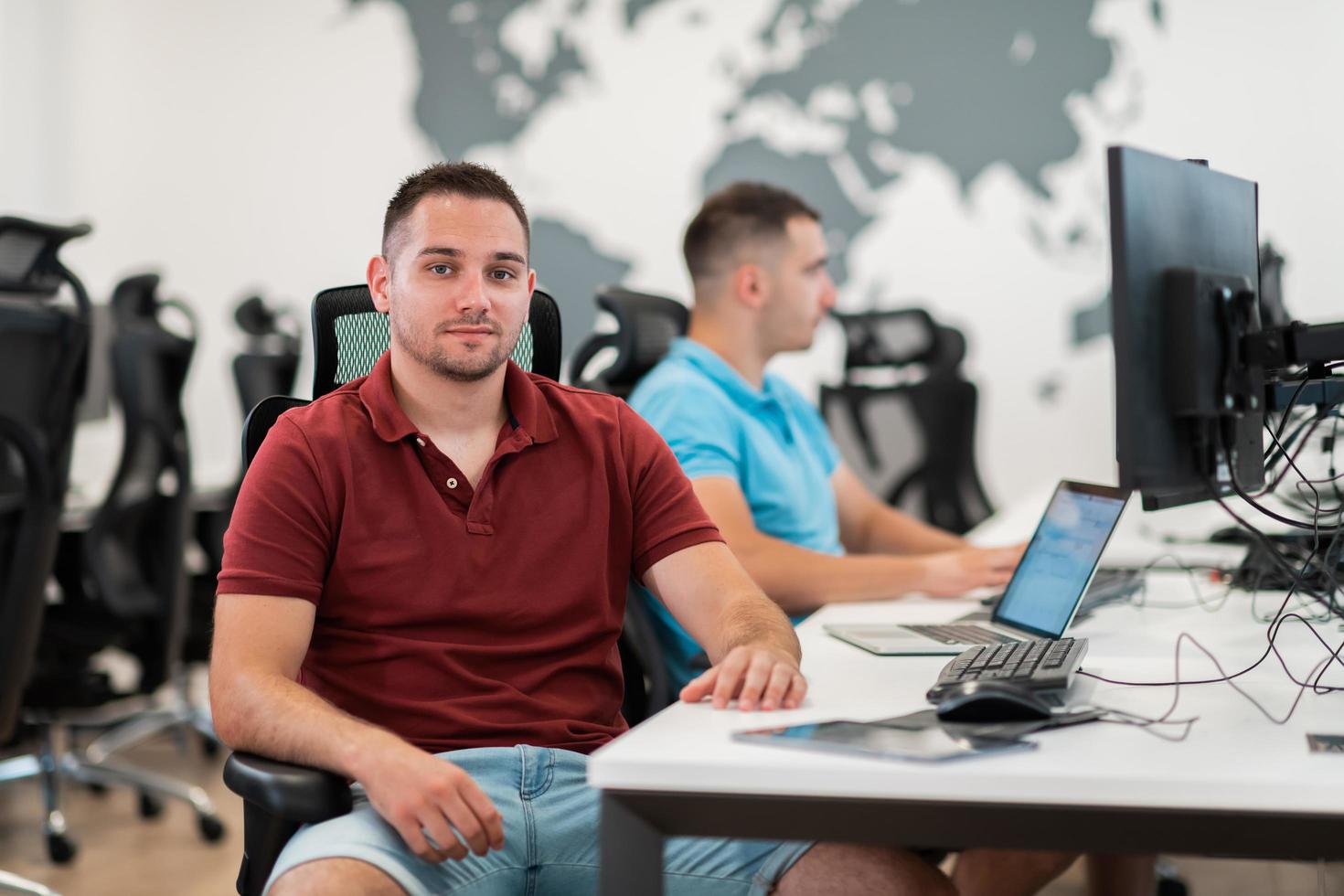 Group of Casual business man working on desktop computer in modern open plan startup office interior. Selective focus photo