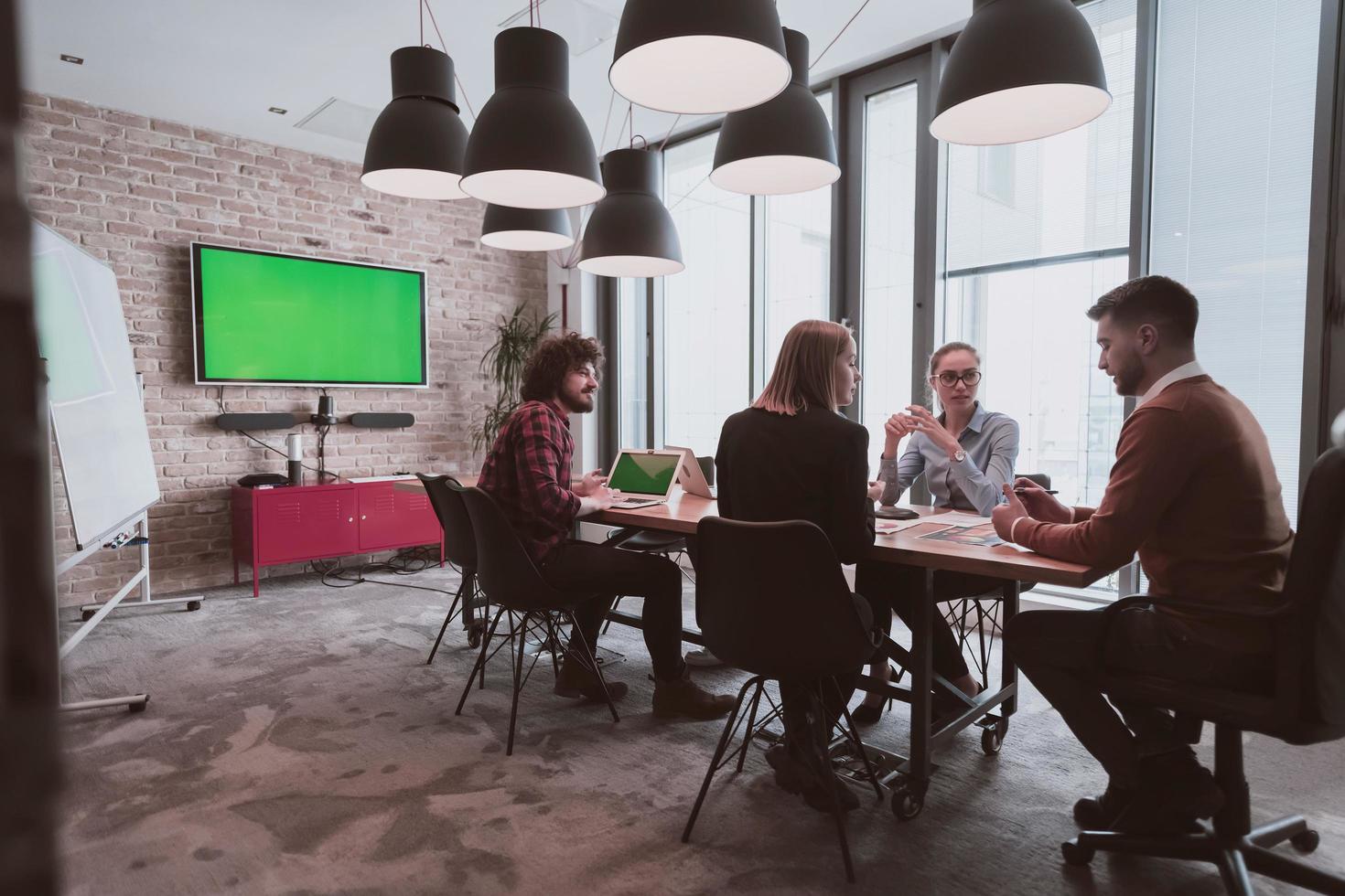 Successful team. Group of young multi-ethnic business people working and communicating together in creative office. Selective focus photo