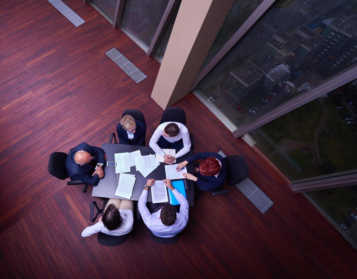 top view of business people group throwing dociments in air photo