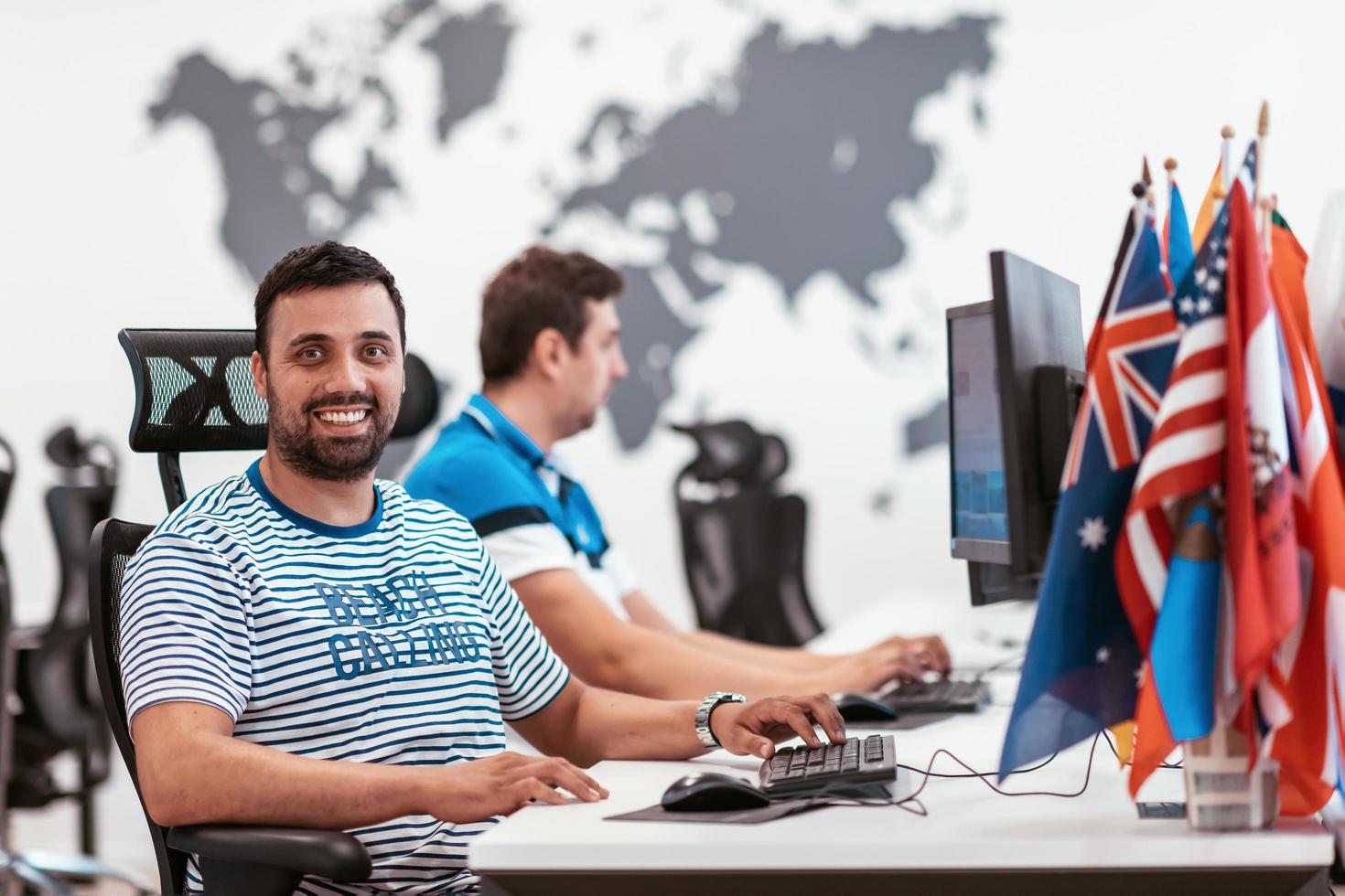 Group of Casual business man working on desktop computer in modern open plan startup office interior. Selective focus photo