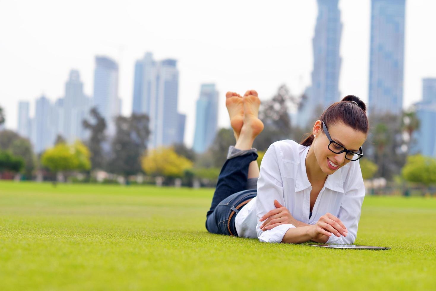 Beautiful young woman with  tablet in park photo