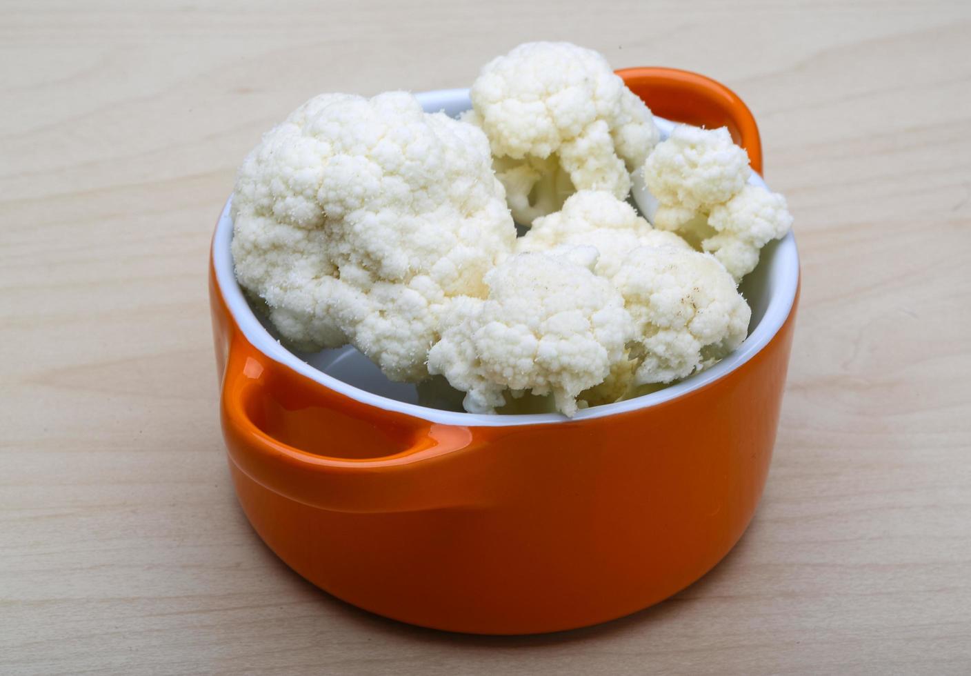 Cauliflower in a bowl on wooden background photo