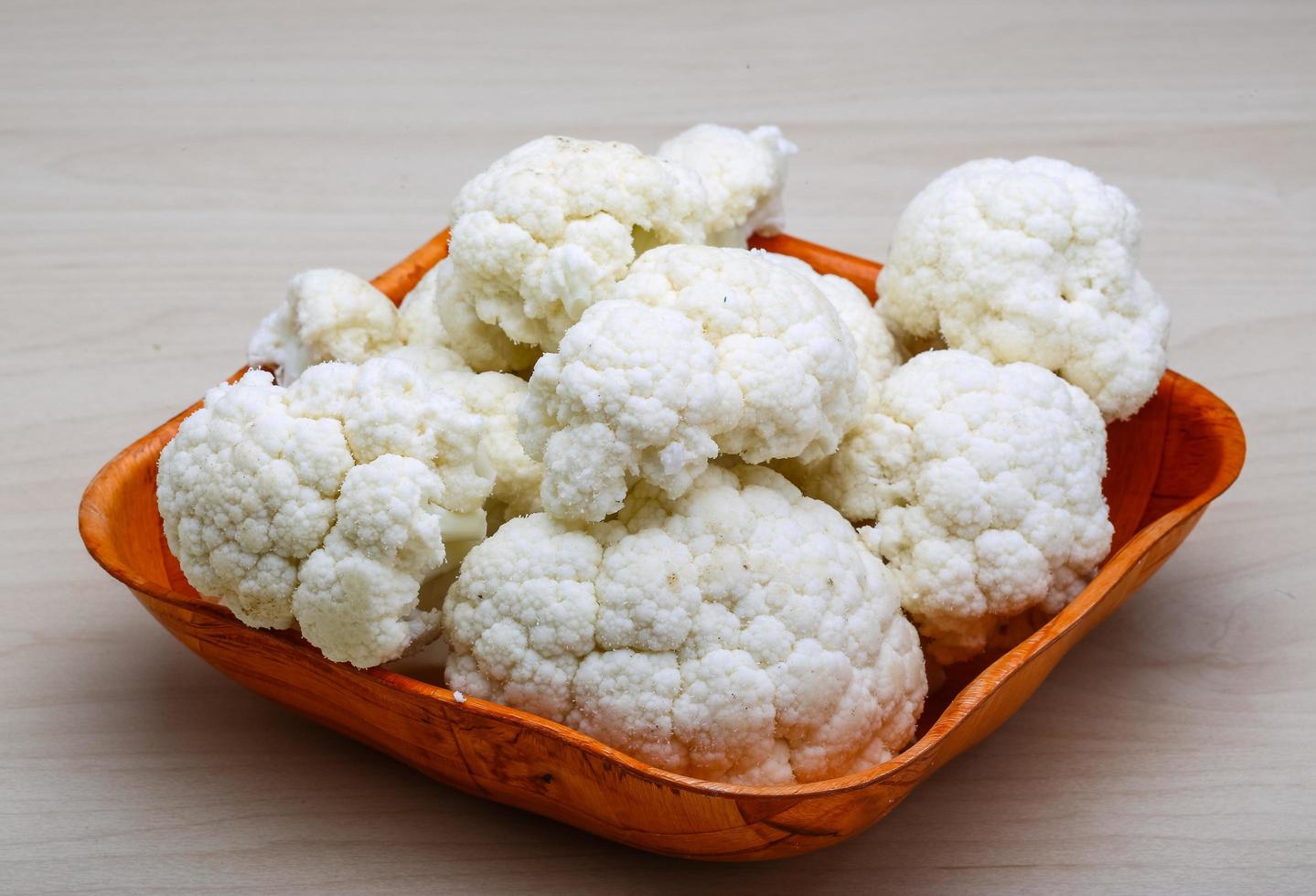 Cauliflower in a bowl on wooden background photo