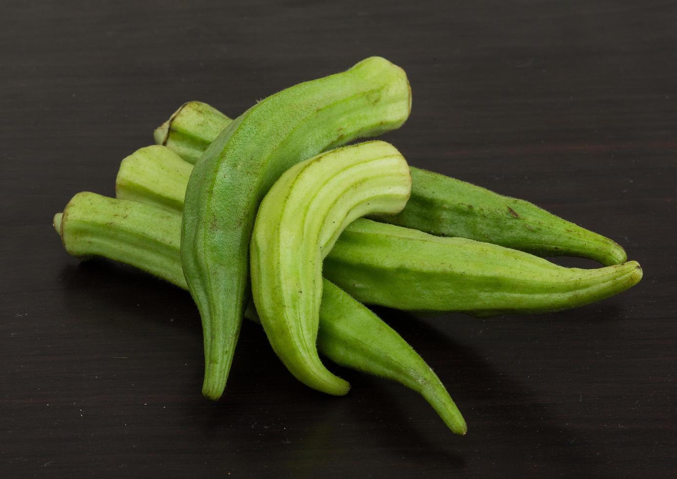 Okra vegetables on wooden background photo