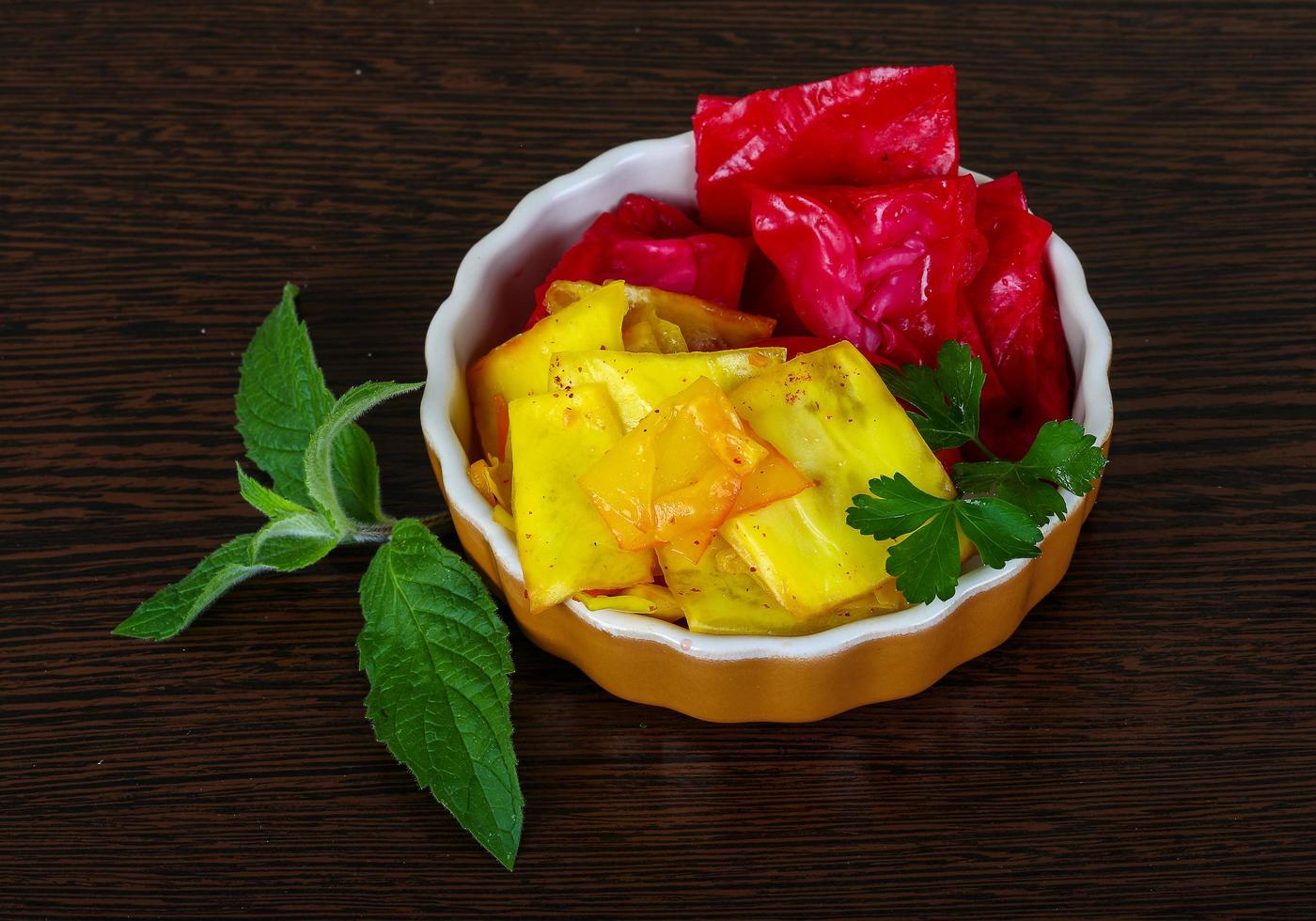 Pickled cabbage in a bowl on wooden background photo