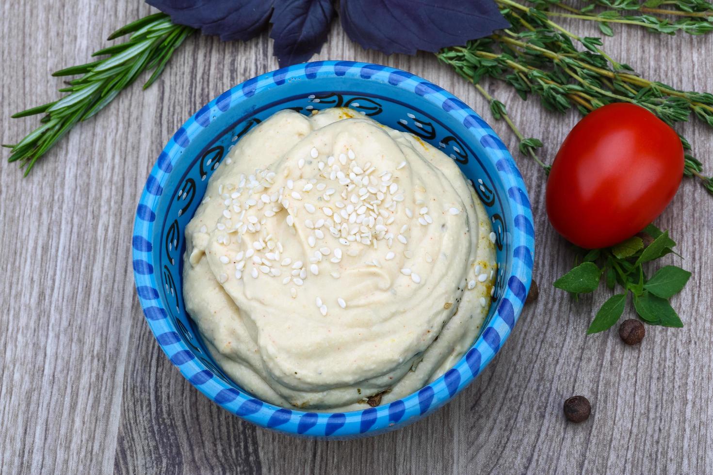 Hummus in a bowl on wooden background photo
