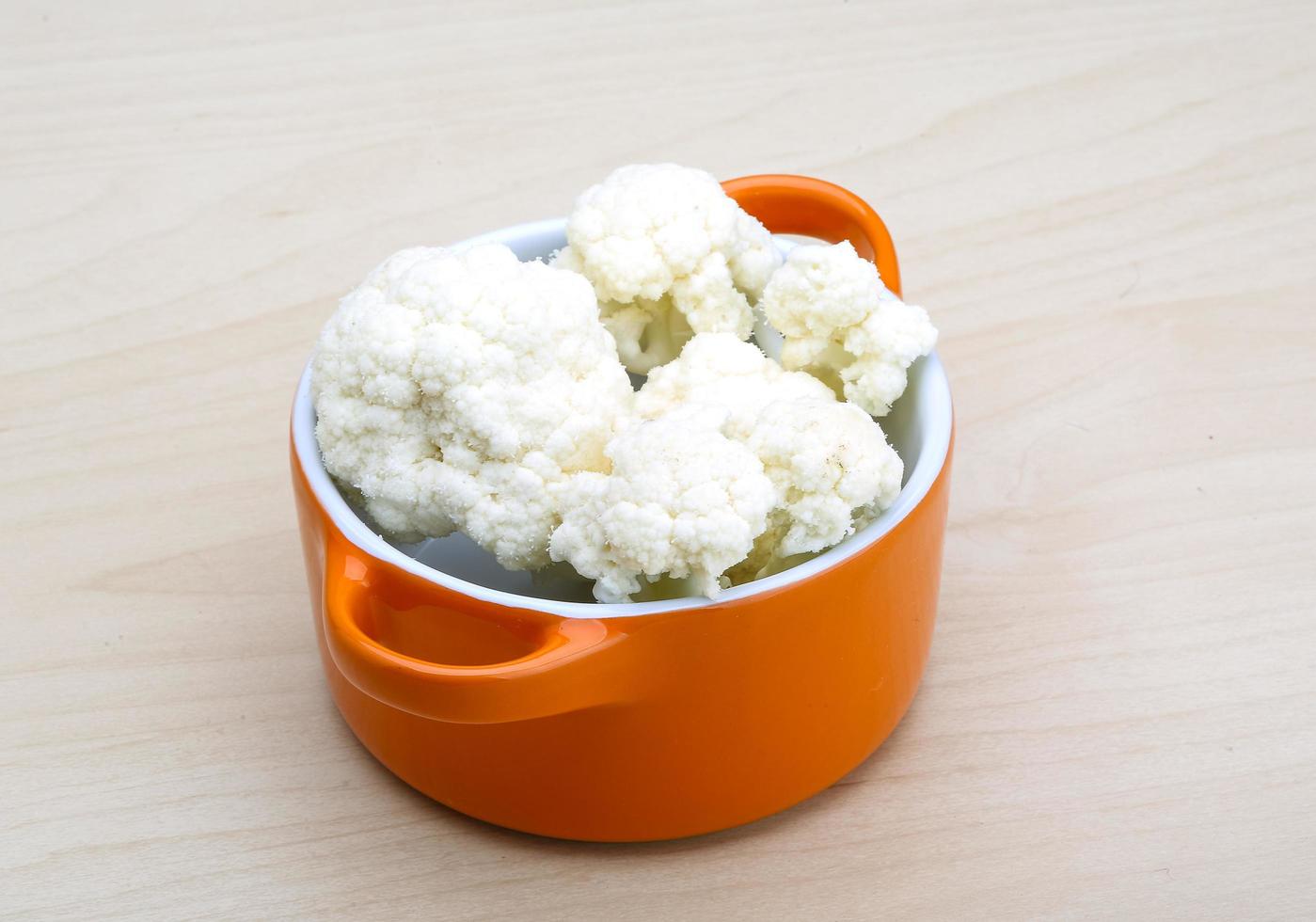 Cauliflower in a bowl on wooden background photo