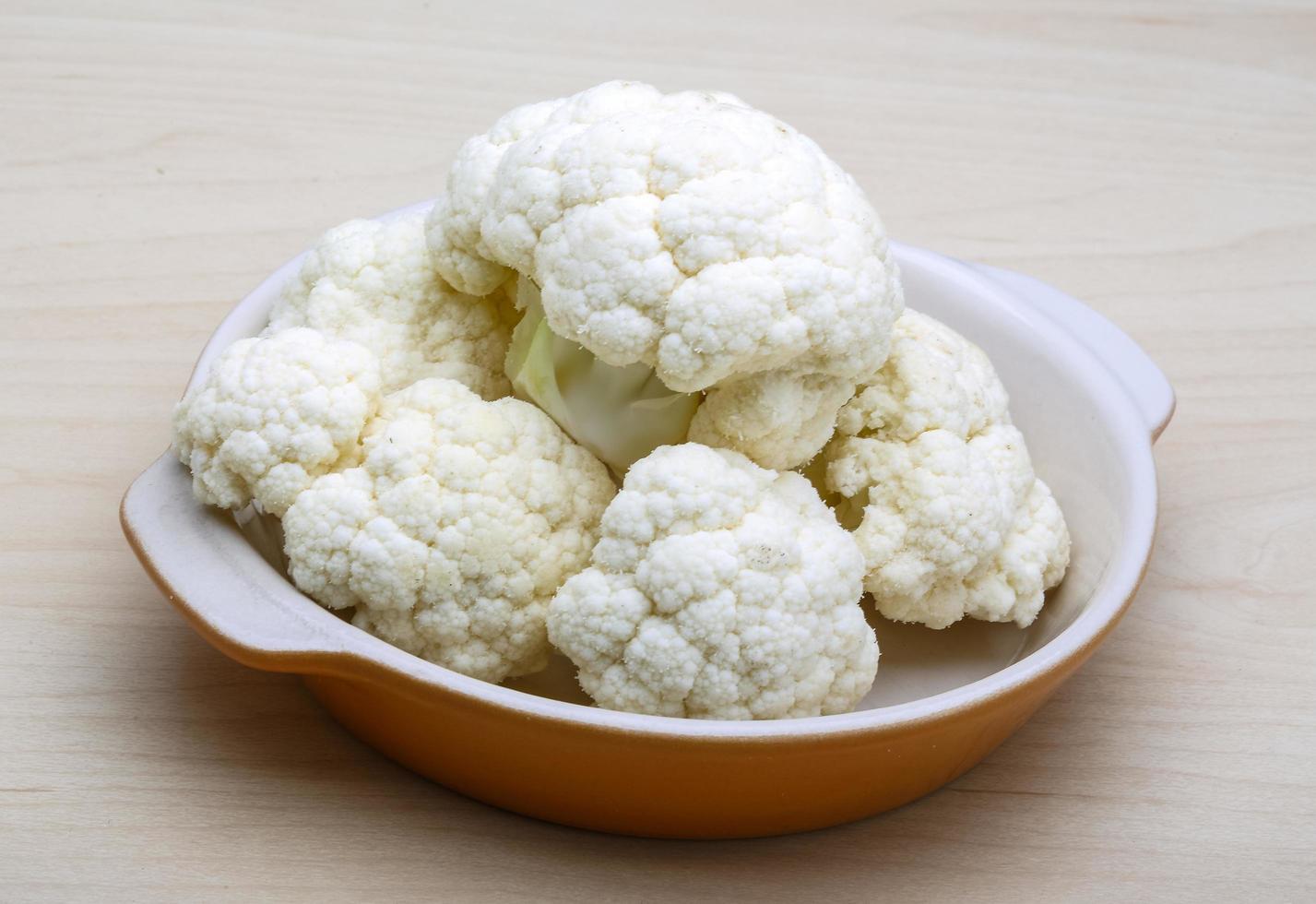 Cauliflower in a bowl on wooden background photo