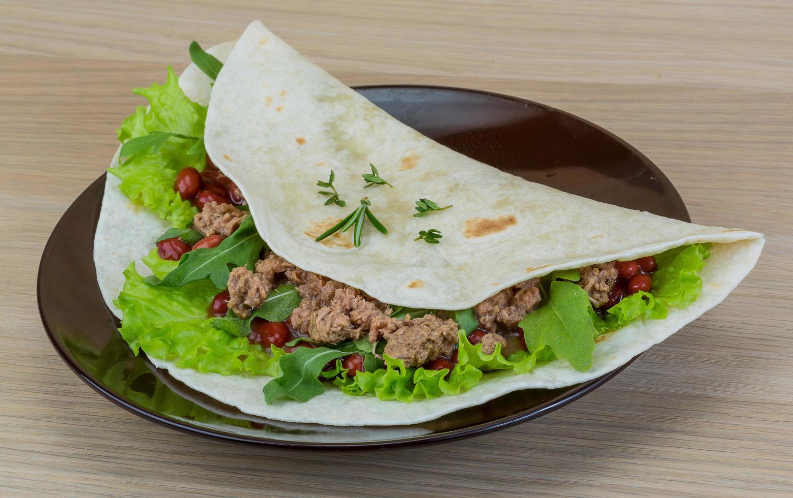 burrito en el plato y fondo de madera foto