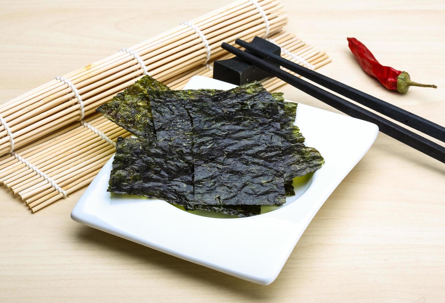 Nori sheets in a bowl on wooden background photo