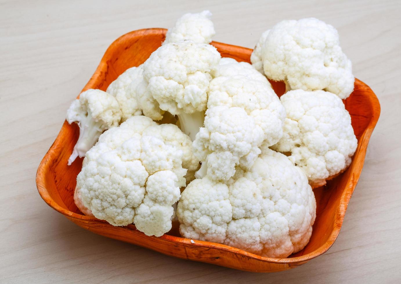 Cauliflower in a bowl on wooden background photo