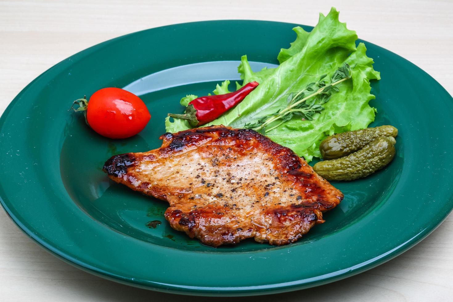 Roasted pork on the plate and wooden background photo