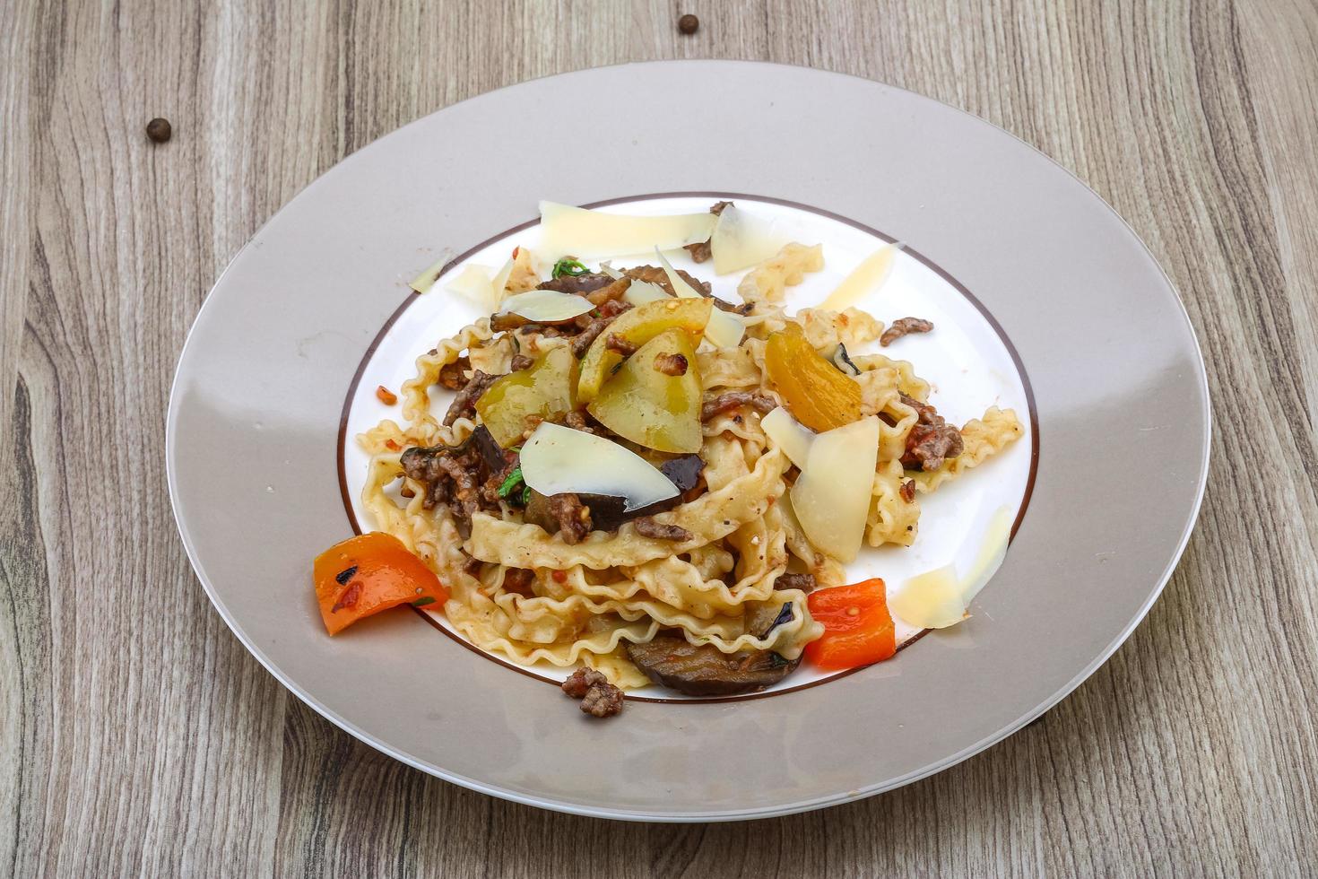 pasta mafalde en el plato y fondo de madera foto