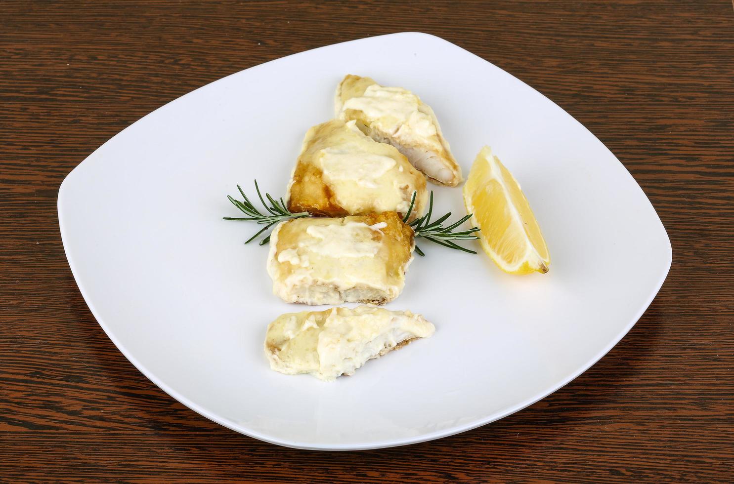 Baked perch on the plate and wooden background photo