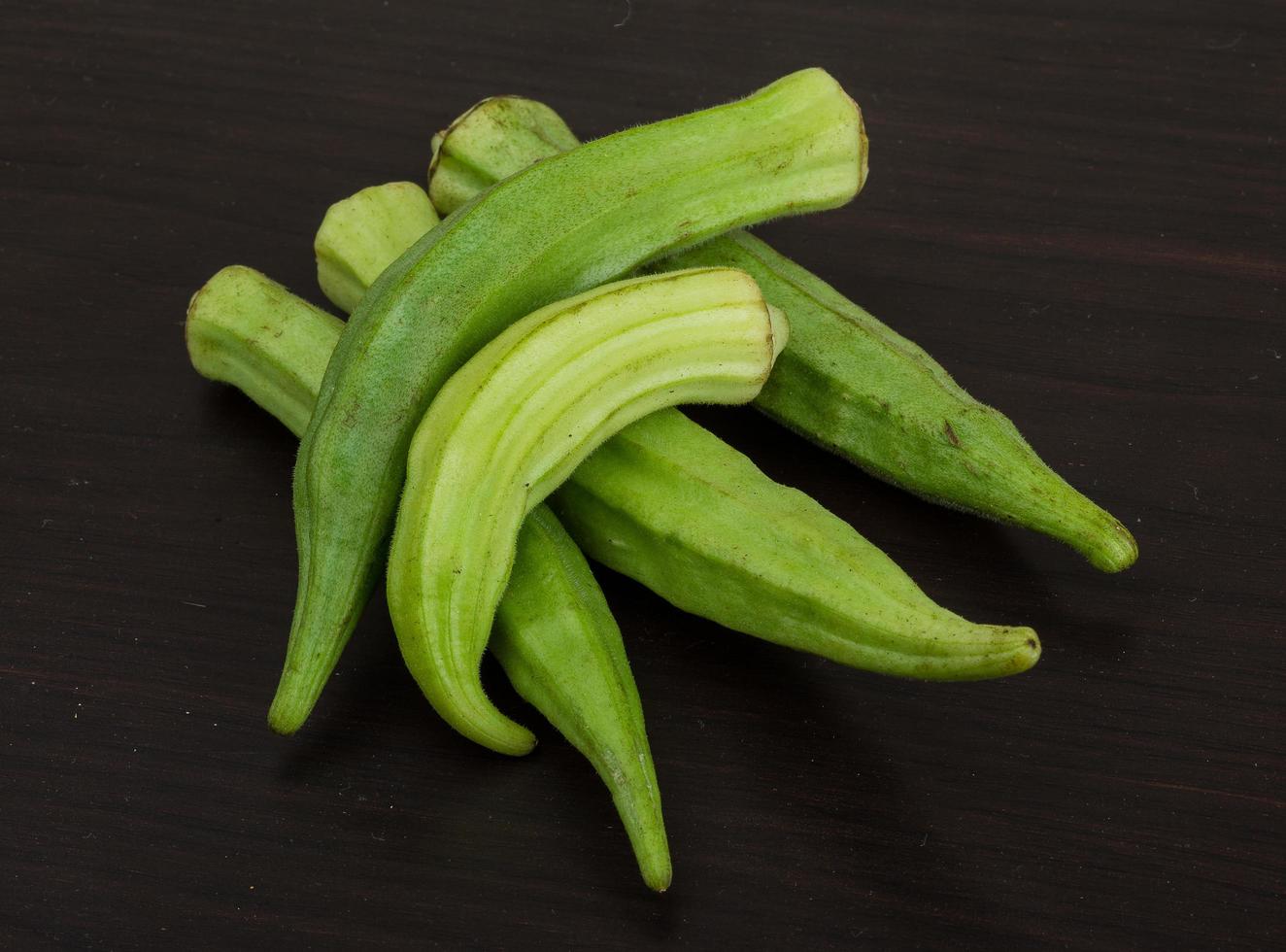 Okra vegetables on wooden background photo