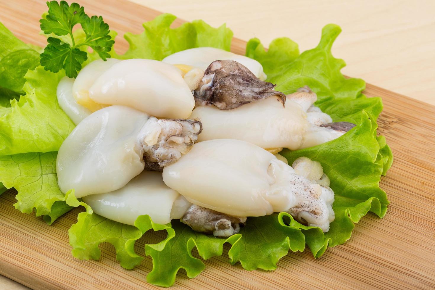 Raw cuttlefish on wooden board and wooden background photo