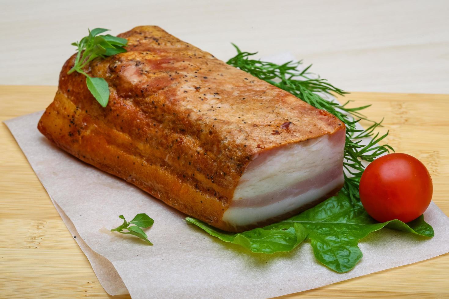 Raw bacon on wooden board and wooden background photo