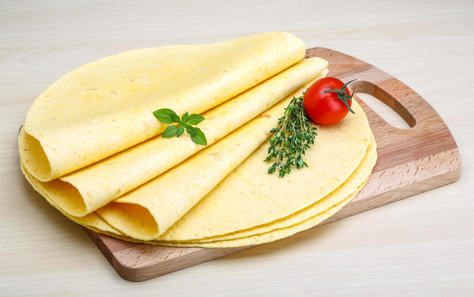 tortilla sobre tablero de madera y fondo de madera foto