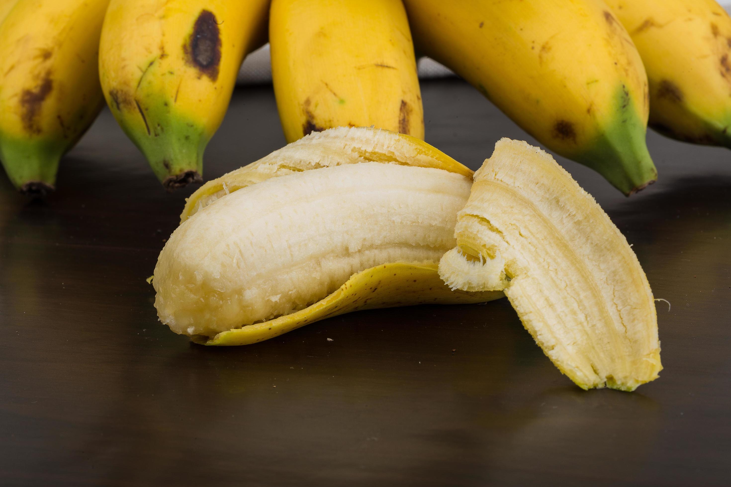 Baby banana on wooden background 12511837 Stock Photo at Vecteezy