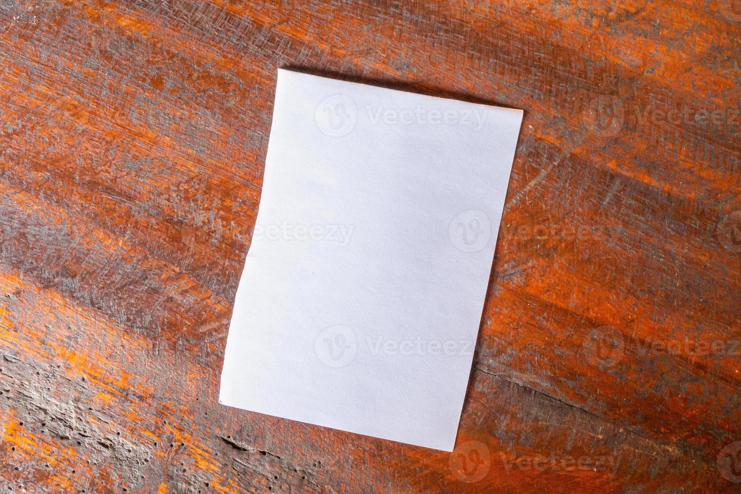 Blank white paper on old rustic wood table background photo