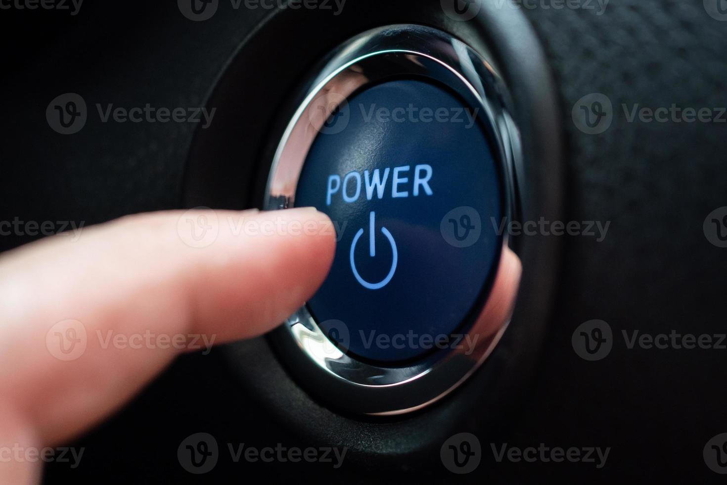 Hand push on car engine power start button close up photo