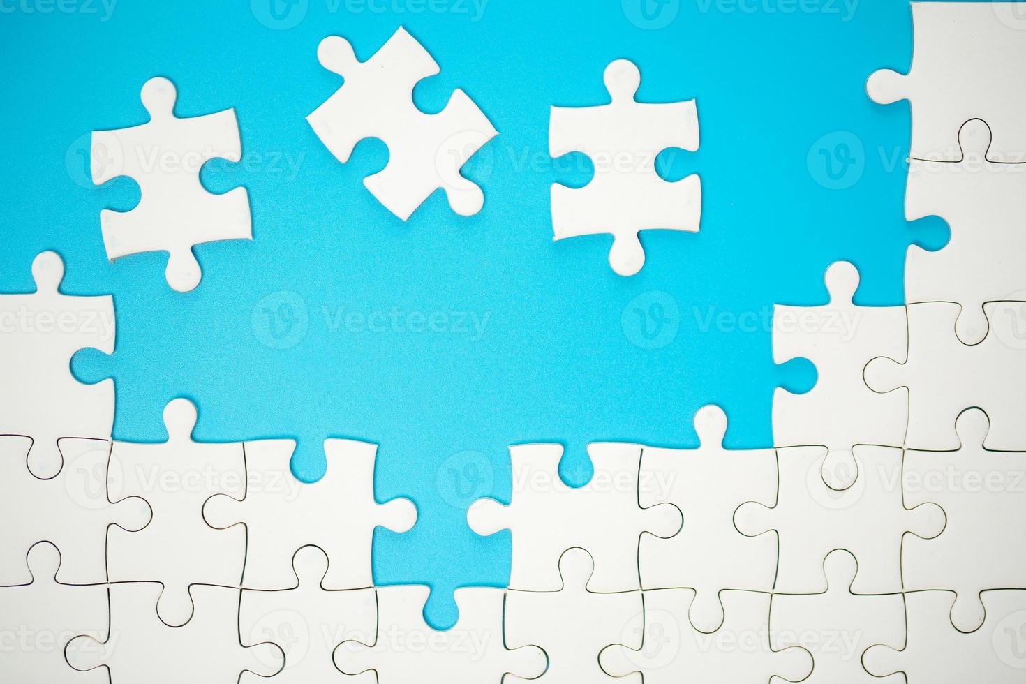 White part of jigsaw puzzle pieces on blue background. concepts of problem solving, business success, teamwork, Team playing jigsaw game incomplete, Texture photo with copy space for text